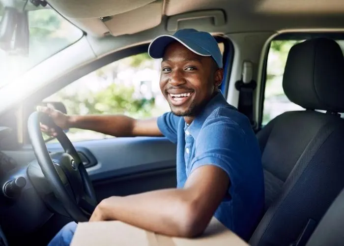 Delivery driver in car with package