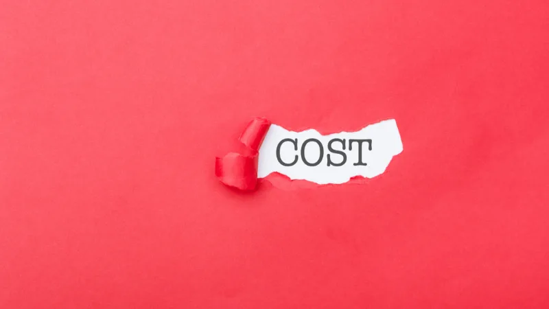 Red paper has been ripped exposing the hidden costs