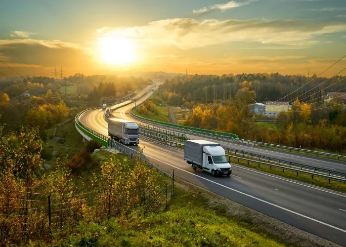 Trucks driving down sunny road