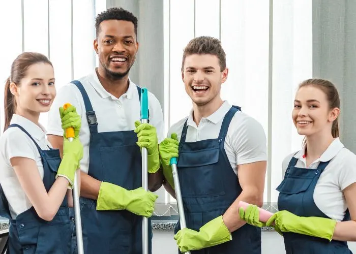 Group of cleaners in overalls and rubber gloves