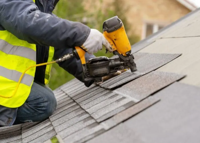 Roofer in a high vis fixing a roof