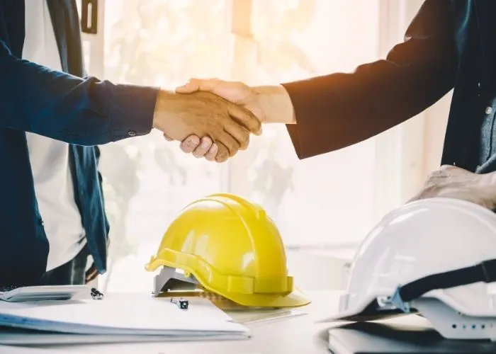 Construction worker shaking customers hand