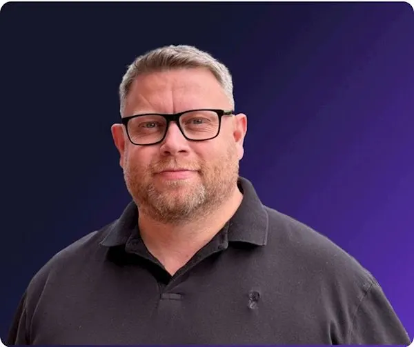 Richard Howard infront of purple background