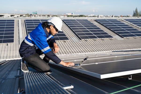 solar panel service engineer adjusting the equipment as part of his assigned job in the job management software app.