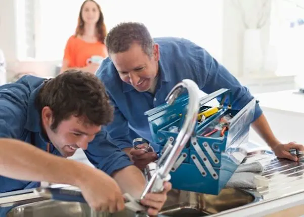 Plumbers working on a kitchen sink