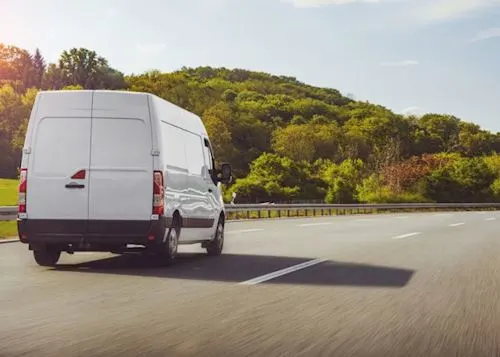 White van driving on a country road