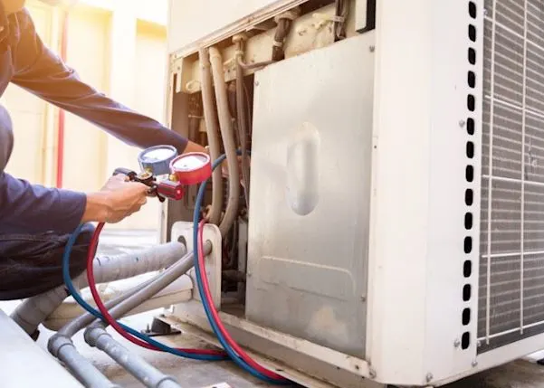 Person carrying out maintenance on an air con unit