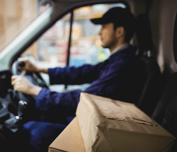 Delivery driver driving his van with packages  in the passenger seat