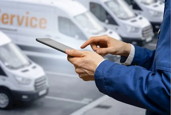 Fleet manager using an iPad to receive real-time alerts from connected AI dash cams in vans