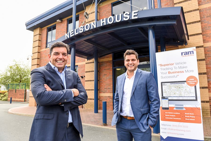Two of RAM Tracking's Leadership team stood outside of the UK office at Nelson House