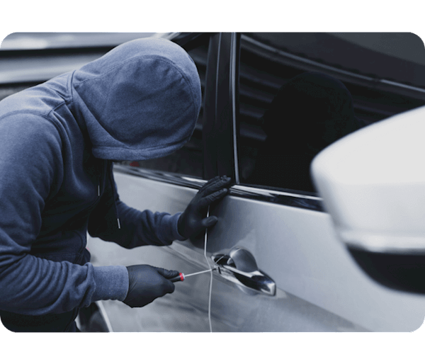 Man in dark blue hoodie attempting to steal a grey car.