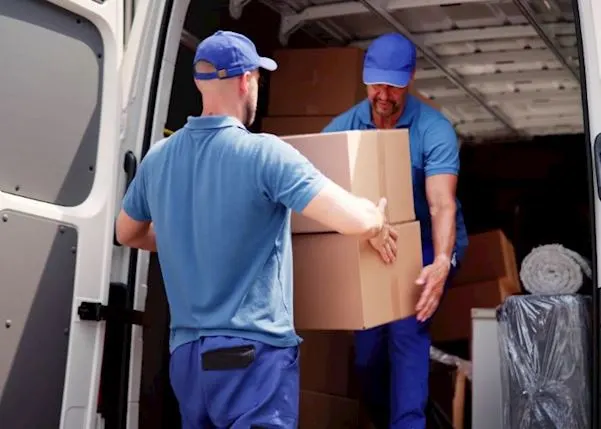 Delivery drivers passing parcels from a van