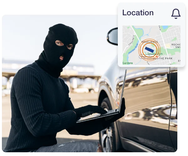 Thief using a laptop beside a car