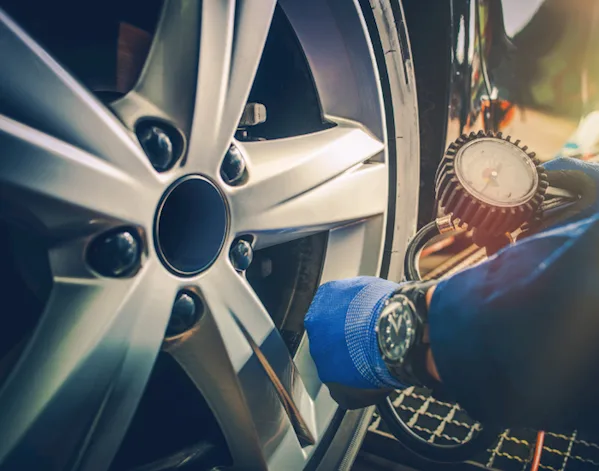 Person checking the tyre pressure of a vehicle